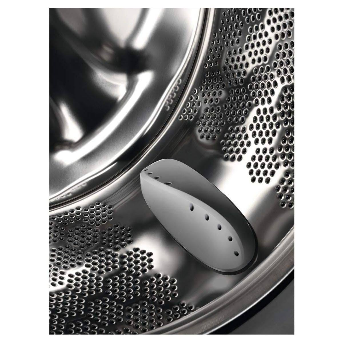 Wnętrze bębna pralki. Biała plastikowa część znajduje się wewnątrz bębna.