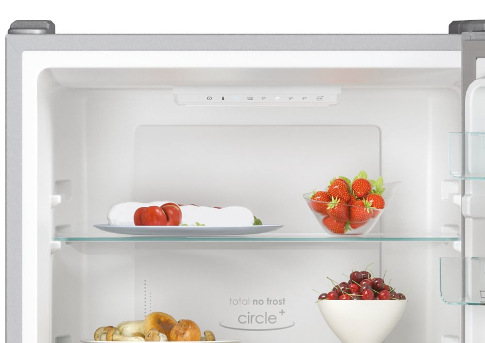 Dentro un frigorifero: frutta e cibo sugli scaffali. Fragole, ciliegie e funghi sono visibili.