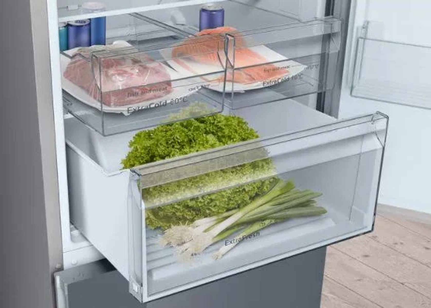 Dentro de un refrigerador. Hay cajones con lechuga, carne y cebolletas.