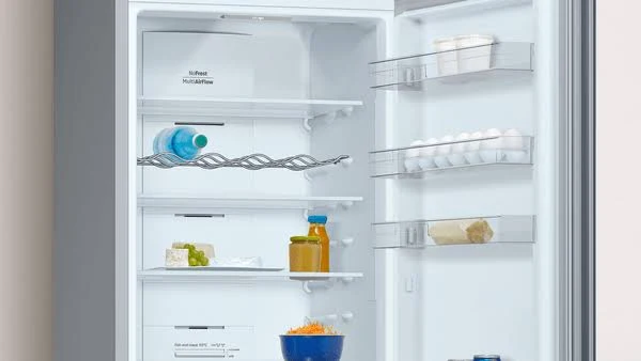 Interior de un frigorífico blanco. Estantes, botellas y alimentos.