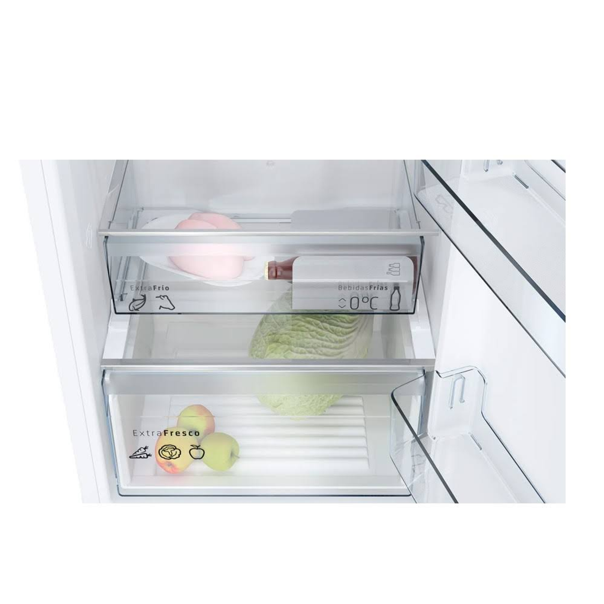 Interior de refrigerador. Cajones con comida, incluyendo frutas y carne. Estantes de vidrio con almacenamiento. Interior blanco.