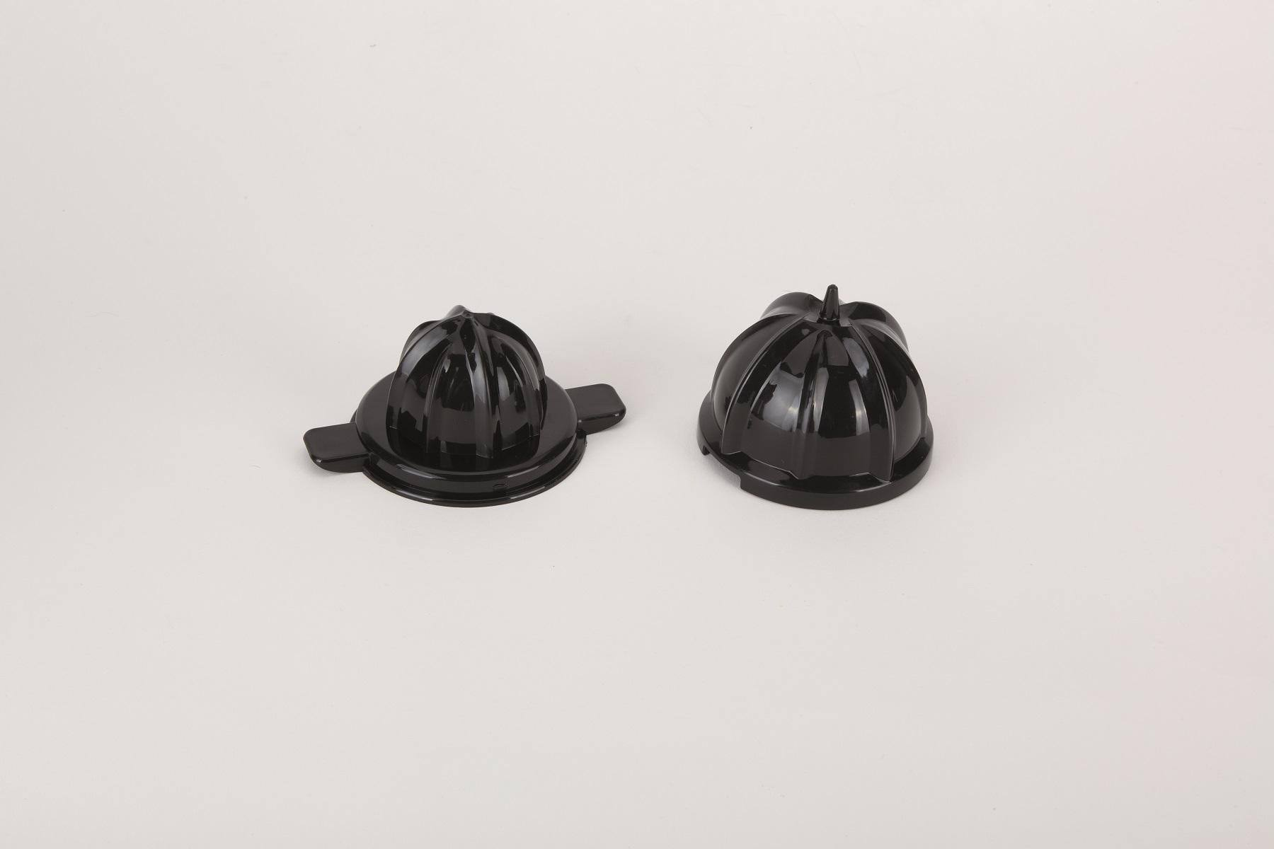Dos piezas negras de exprimidor de cítricos sobre superficie blanca.