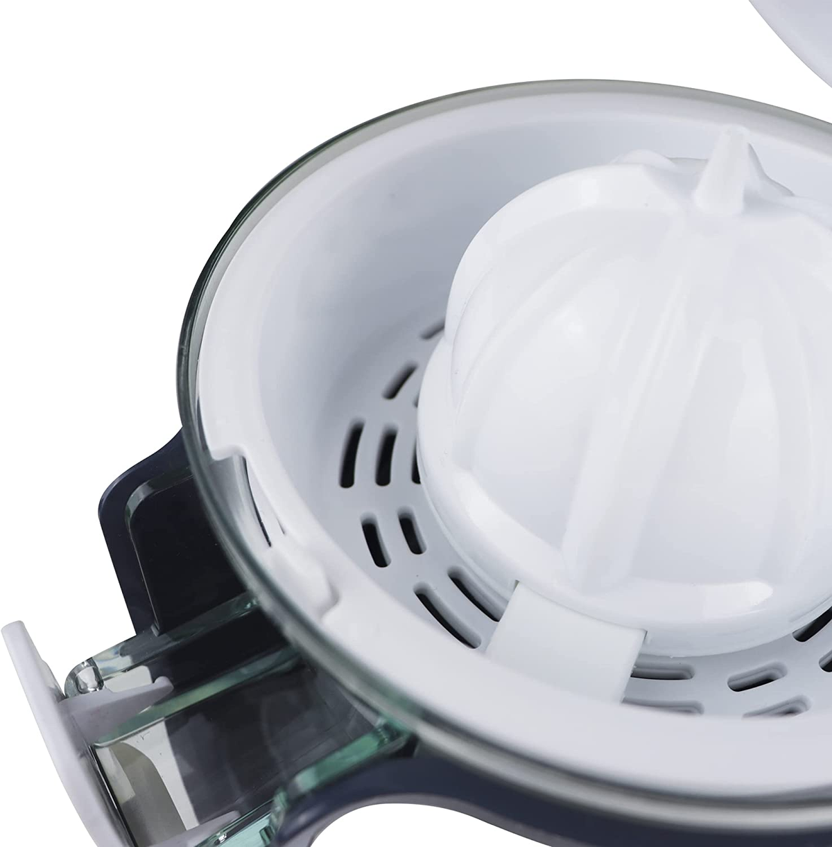Primer plano de los componentes del exprimidor. Reamer blanco, recipiente transparente y base oscura.