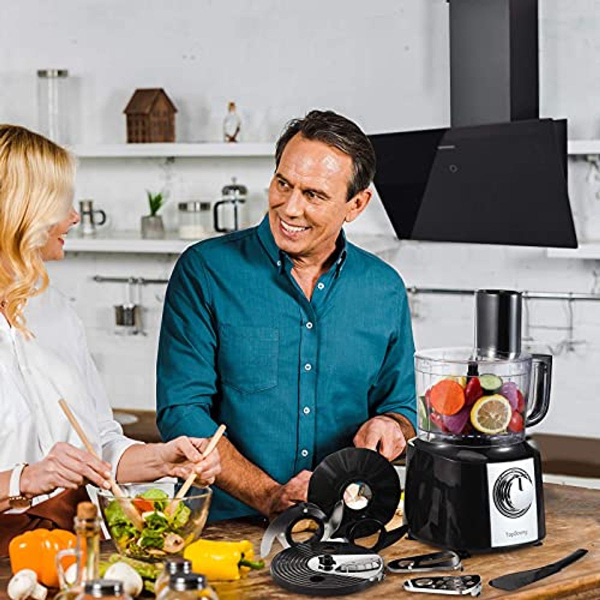 Persone che usano un robot da cucina. Uomo e donna sorridono. Ambiente cucina con ingredienti.