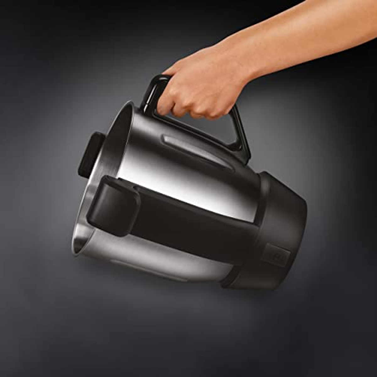 Glänzender silberner Behälter, der von einer Hand gehalten wird. Schwarze Griff- und Basisdetails.