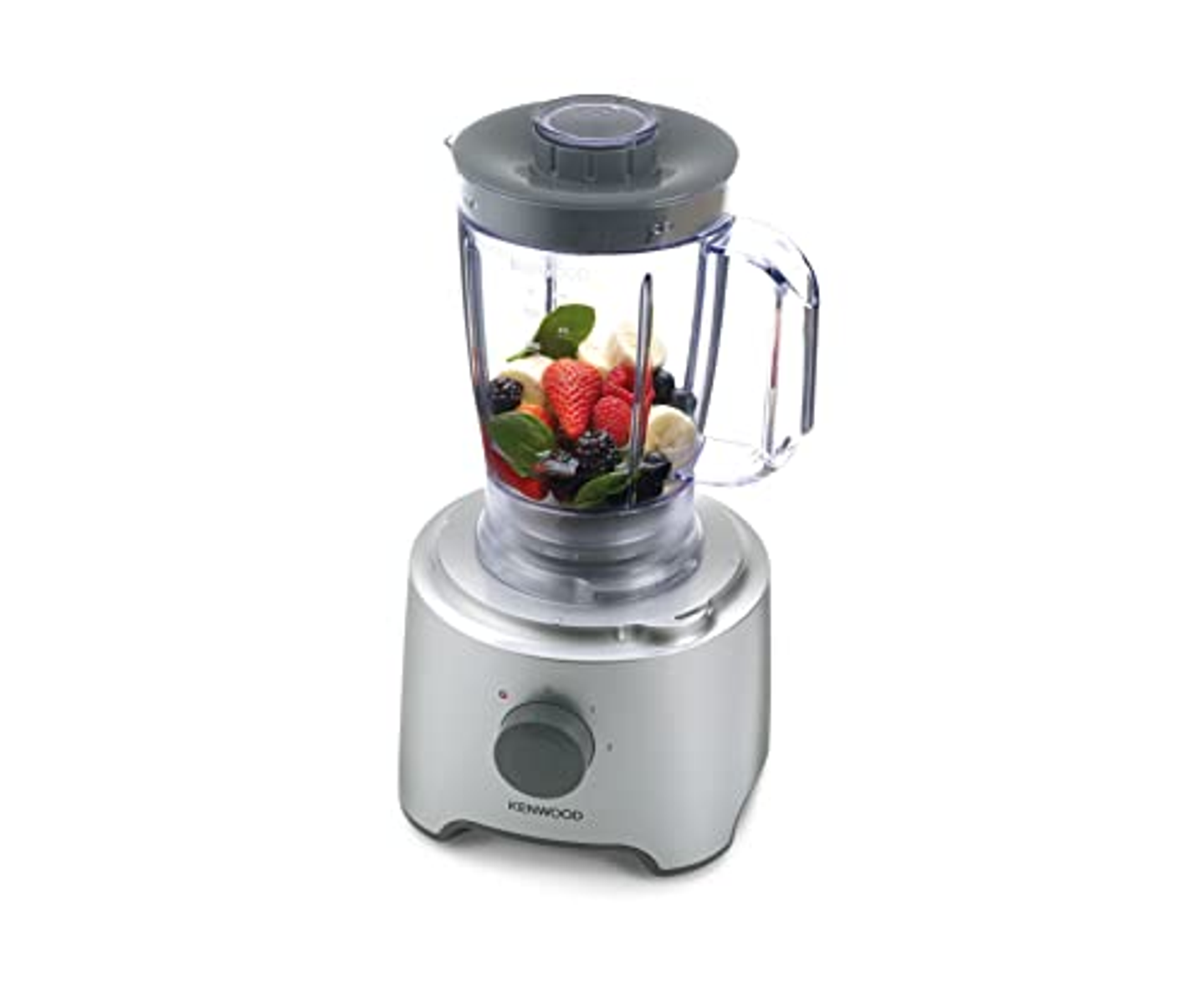 Un frullatore argentato con frutta all'interno. Ci sono fragole, banane e more.