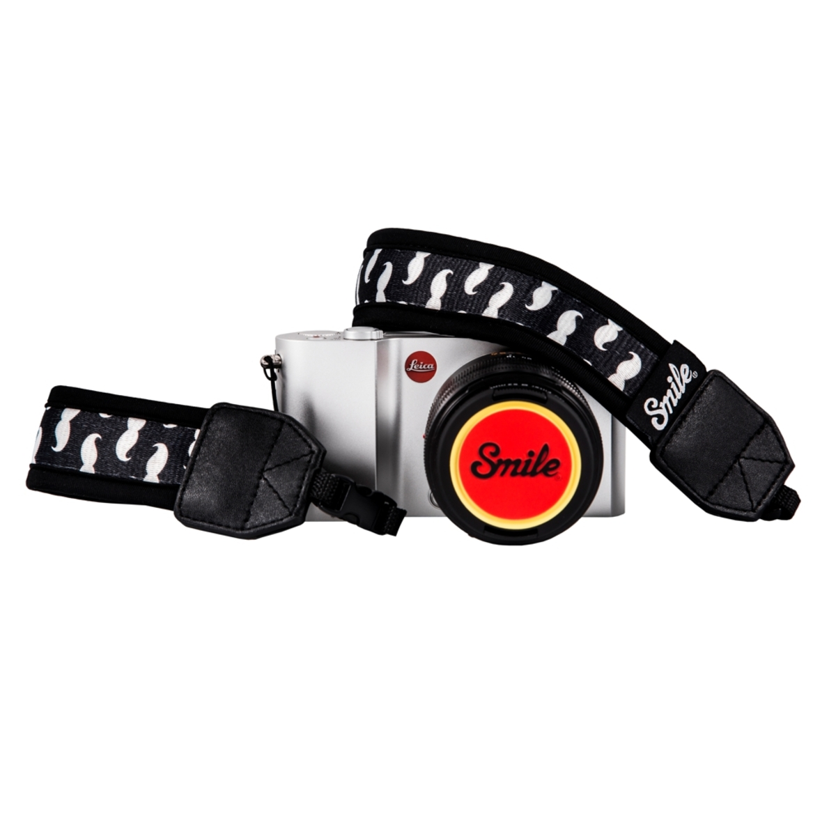 Fotocamera argentata con cinturino bianco e nero. L'obiettivo ha una copertura rossa e gialla.
