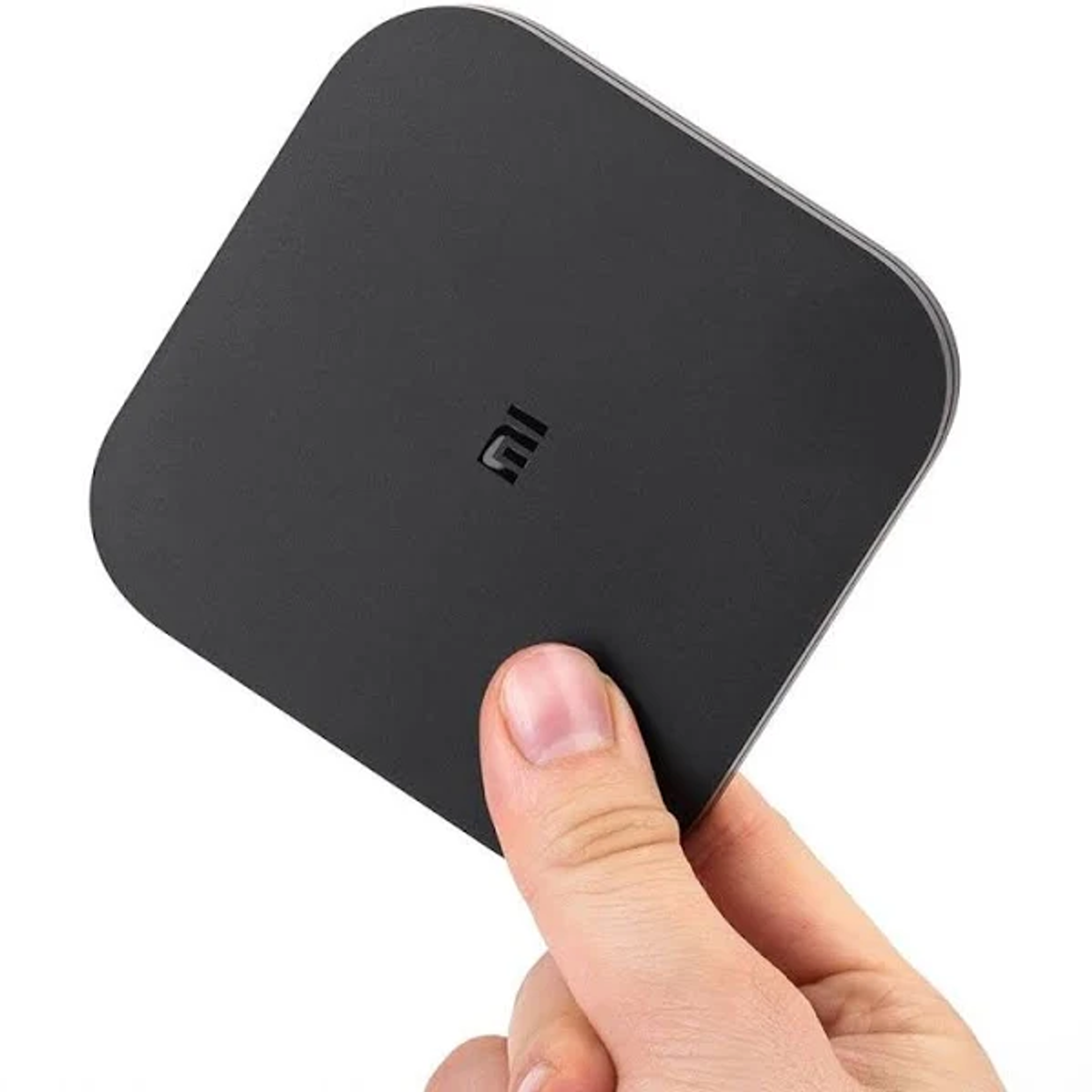 Hand hält ein schwarzes quadratisches kabelloses Ladegerät mit weißem Hintergrund.