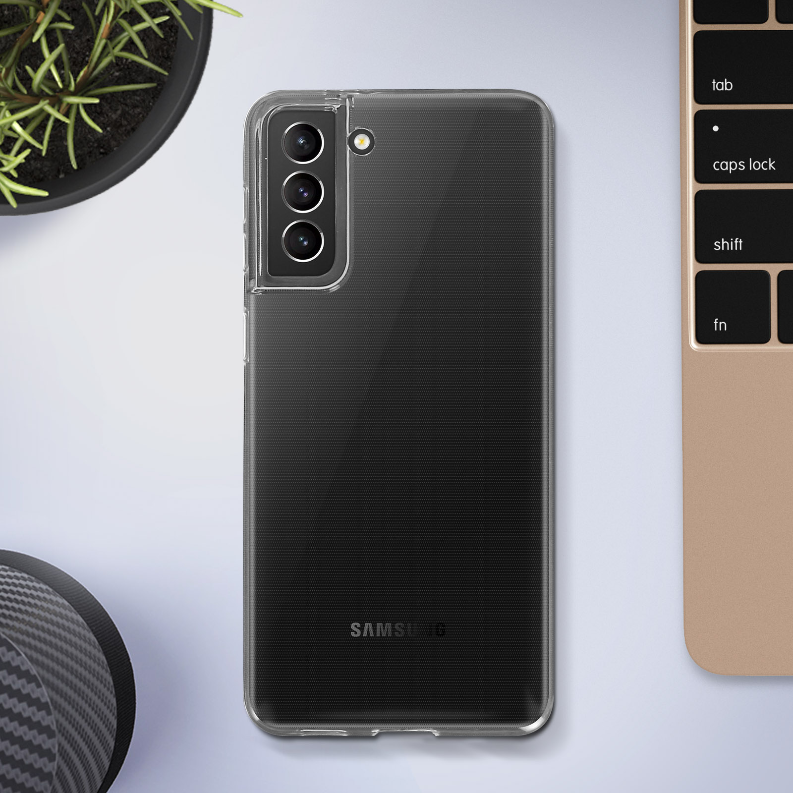 Une coque de téléphone noire avec un téléphone à l'intérieur, à côté d'un clavier sur un bureau.