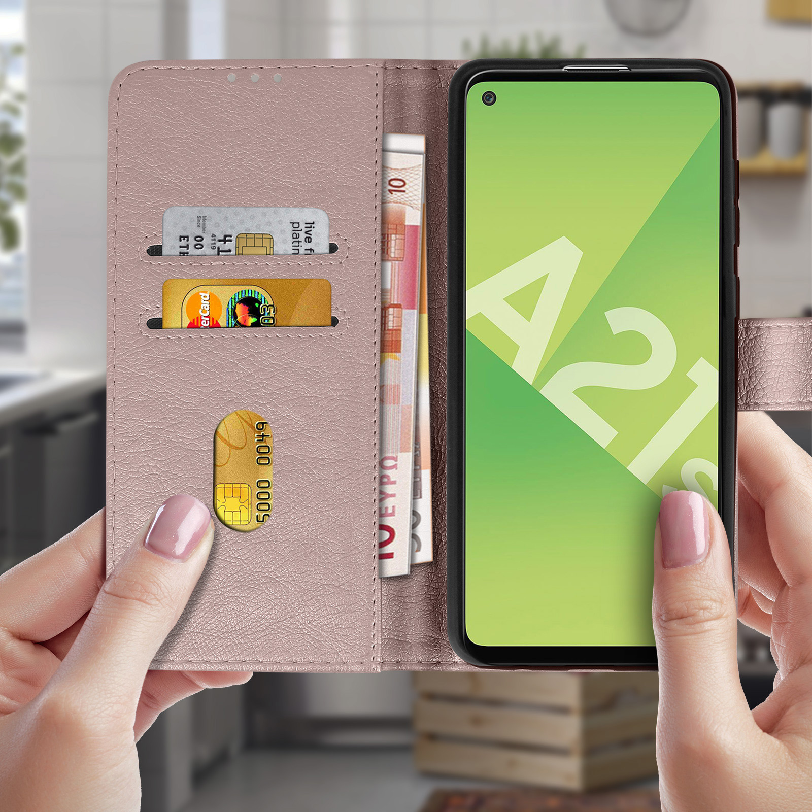 Una custodia rosa per telefono con telefono, slot per carte e denaro. Mani tengono la custodia.