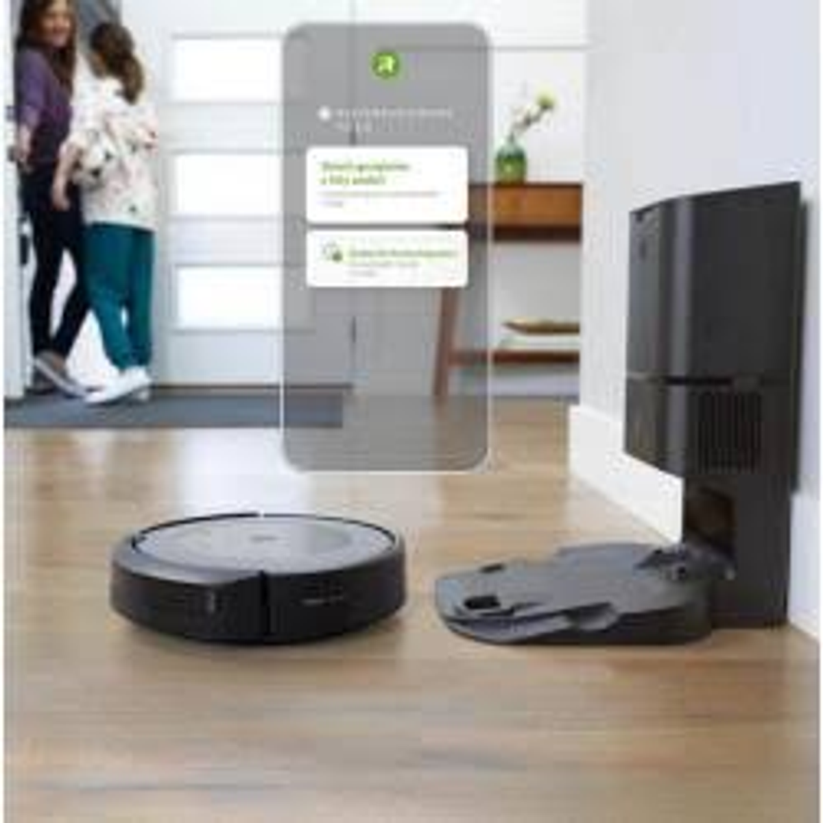 Roboter-Staubsauger auf Holzboden. Ein Telefon zeigt den Reinigungsstatus an.