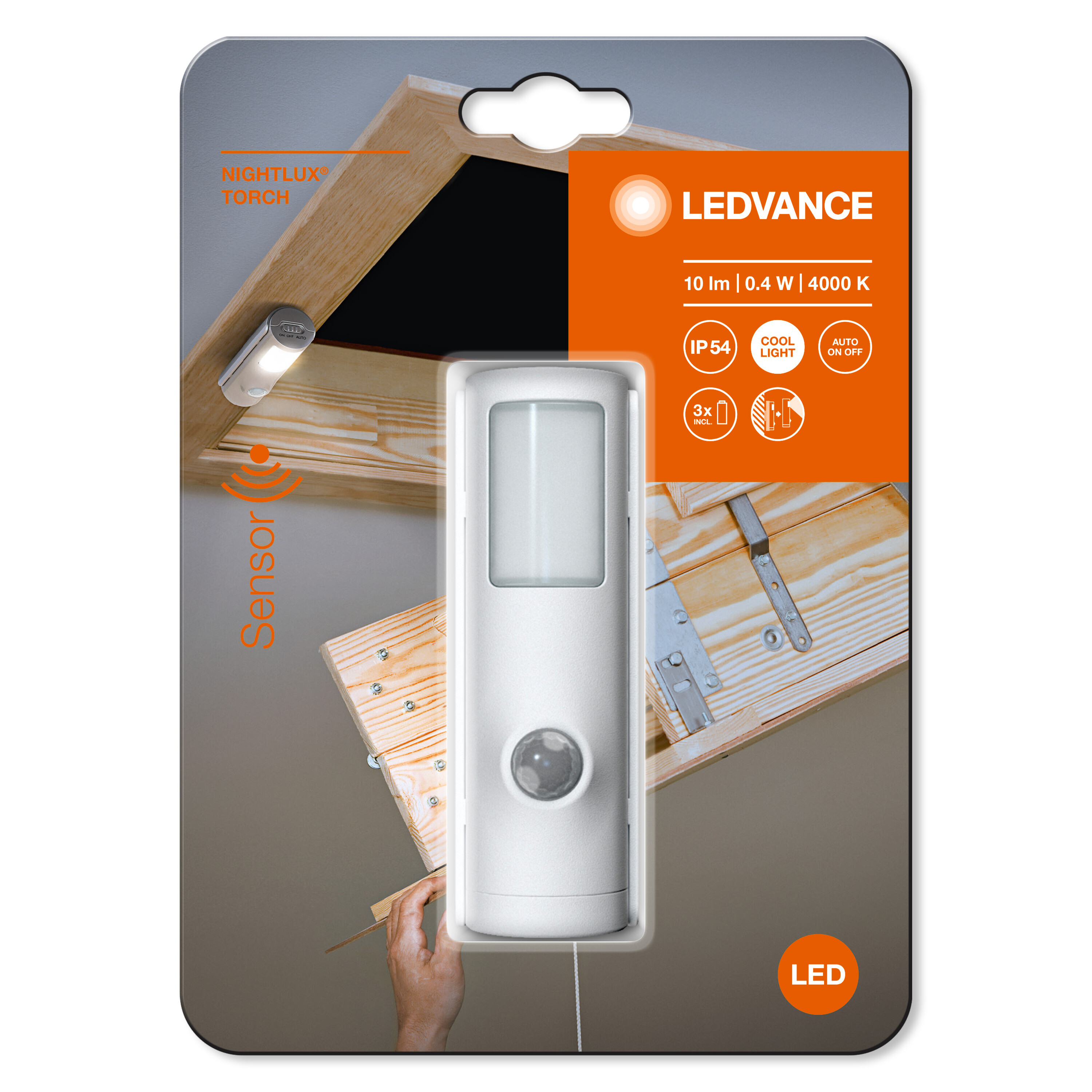 Ein weißes LED-Nachtlicht befindet sich in seiner Verpackung, gezeigt mit einer Hand und Holzoberfläche.