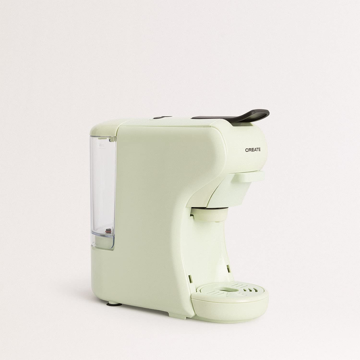 Una máquina de espresso verde claro. Está sobre una superficie blanca. La marca CREATE es visible.