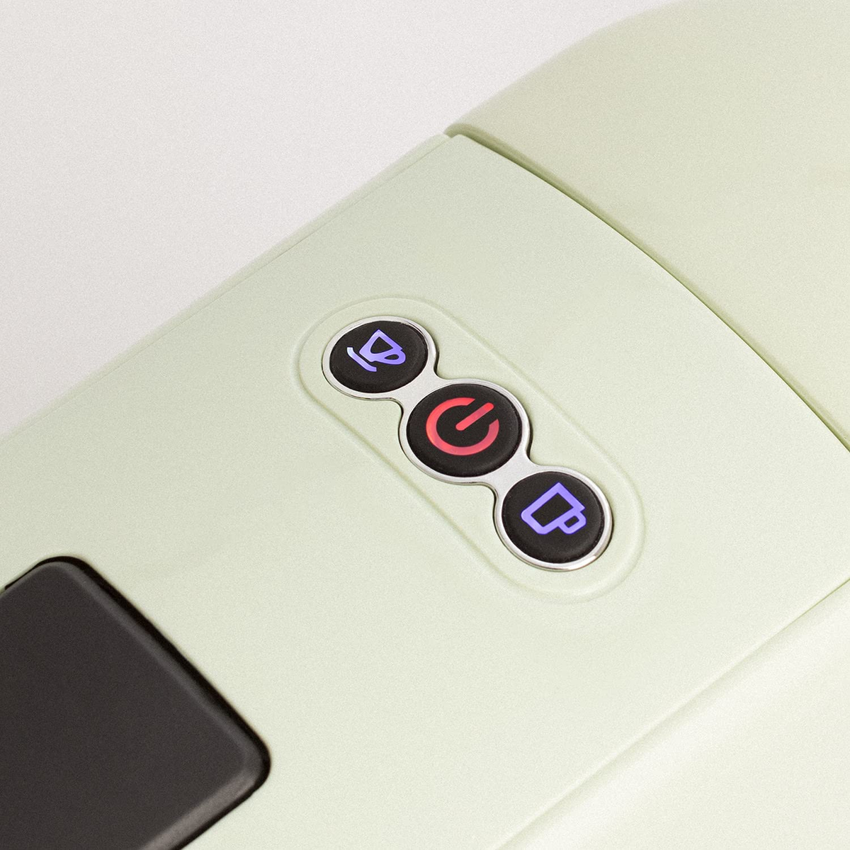 Primer plano de un dispositivo verde claro con tres botones, iconos de encendido y taza de café.