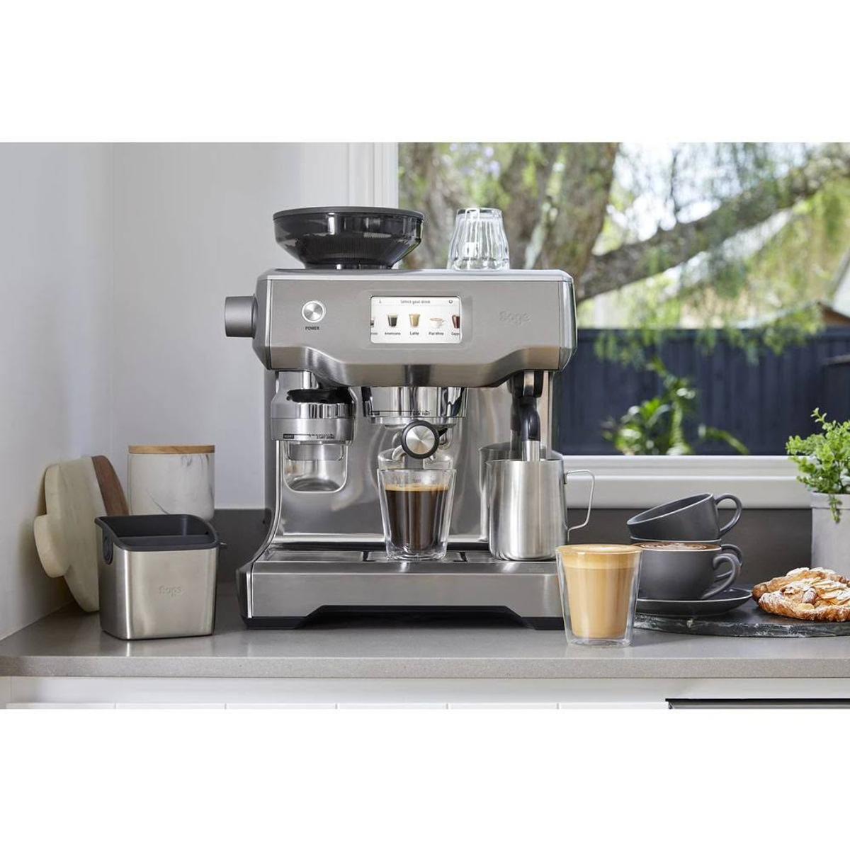 Espressomaschine mit Zubehör und Kaffee in Gläsern. Küchenumgebung.