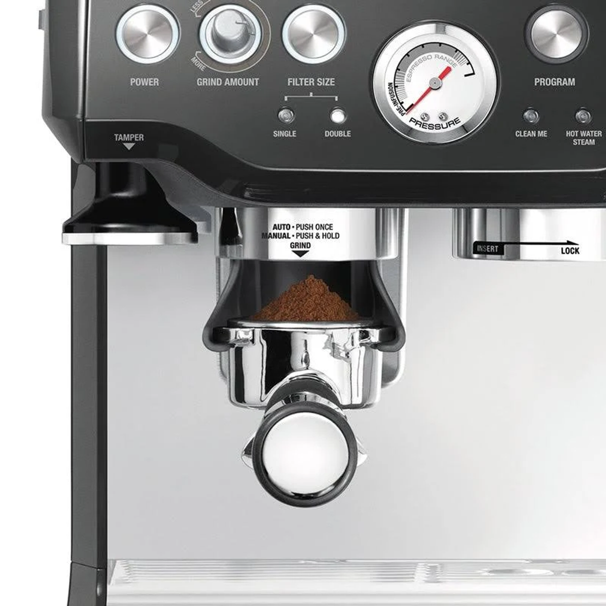 Gros plan sur une machine à café : Porte-filtre avec café moulu, manomètre et boutons. C'est sur un comptoir.