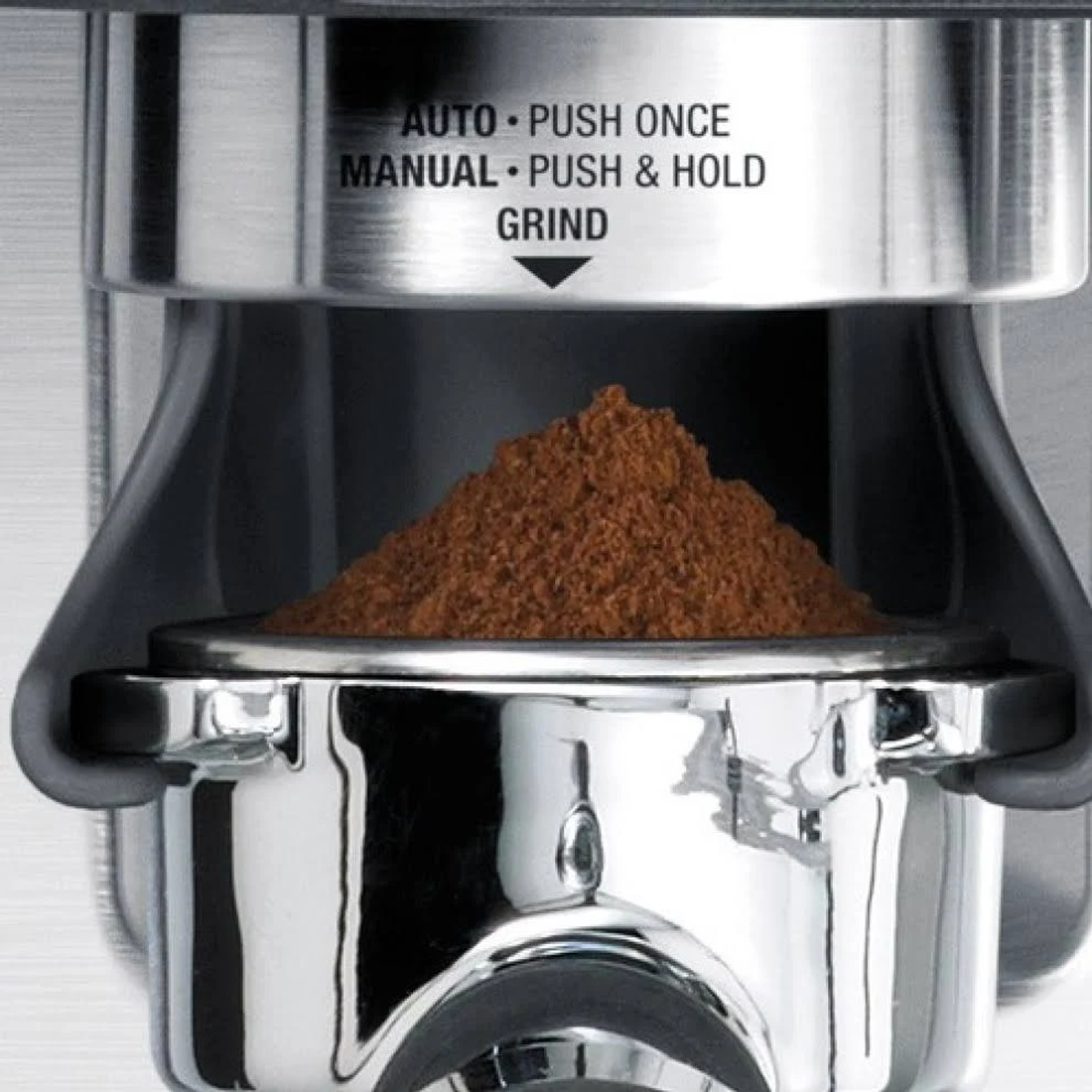 Gros plan sur un moulin à café, montrant du café moulu. Instructions: AUTO, MANUAL et GRIND.