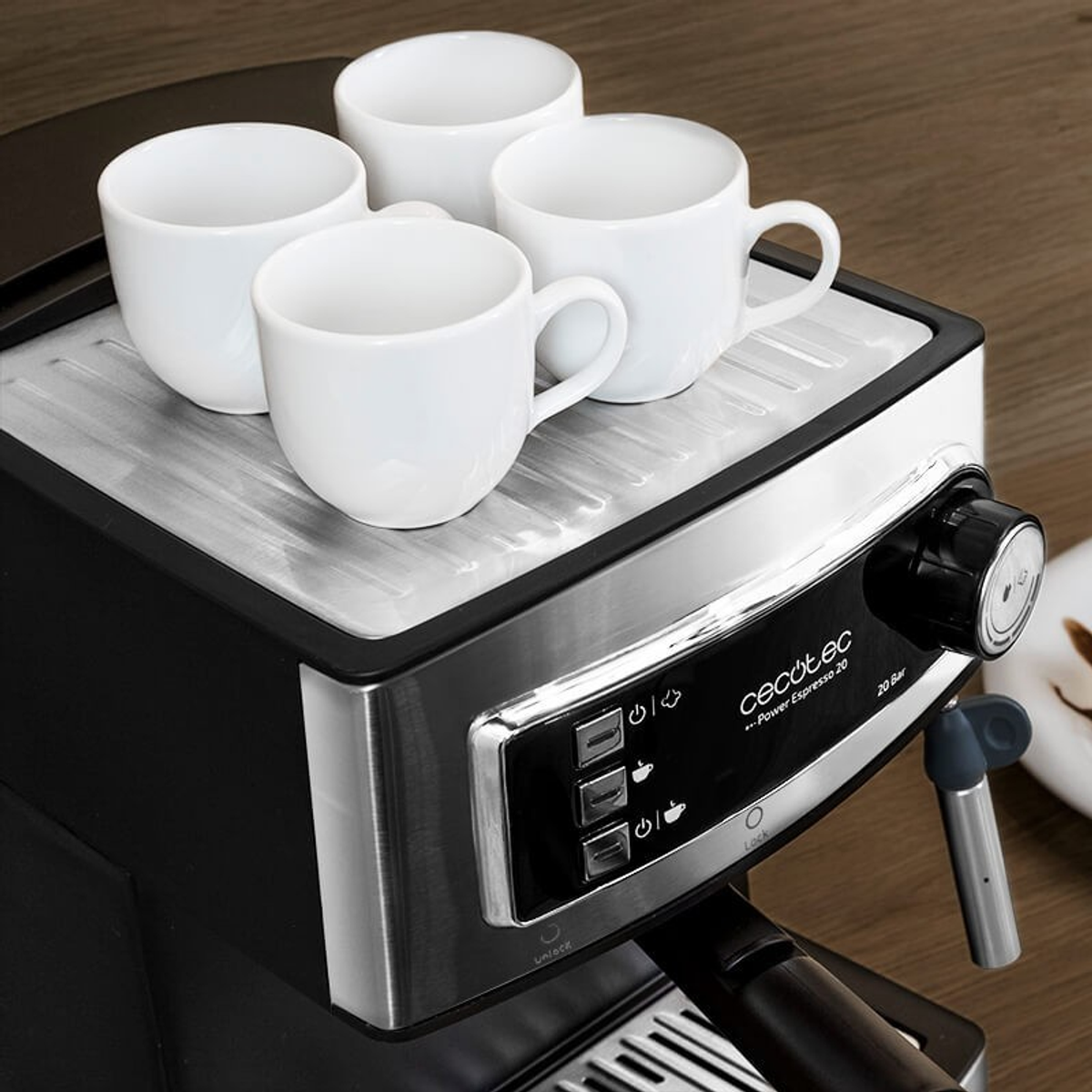 Espressomaschine mit vier weißen Tassen oben. Die Maschine ist schwarz und silber.