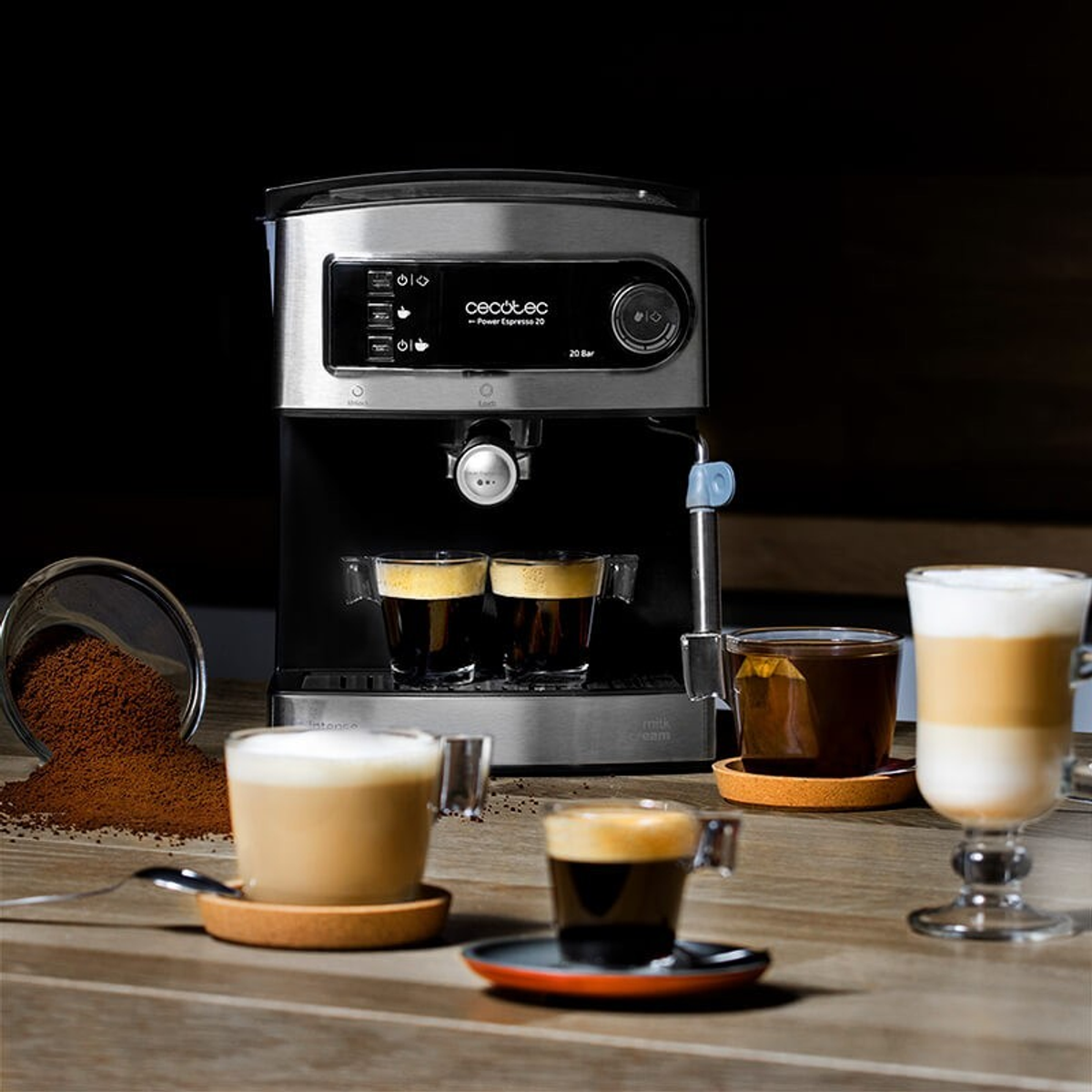 Kaffeemaschine mit Kaffeetassen und Kaffeepulver auf einem Holztisch.