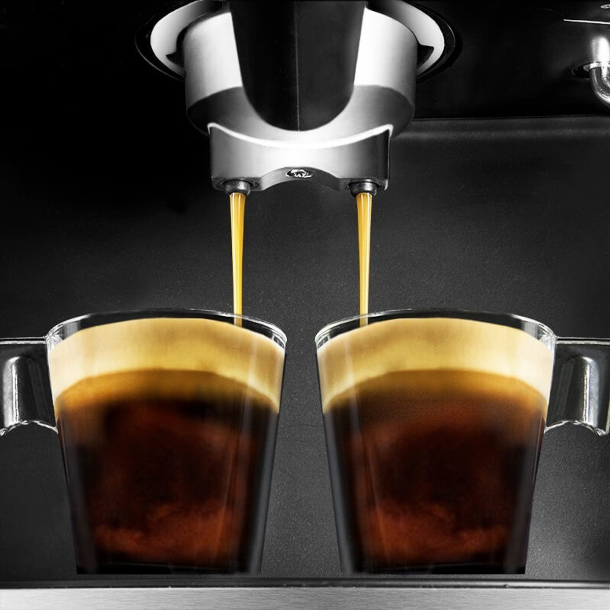 Espressomaschine, die Kaffee in zwei transparente Gläser ausgibt.