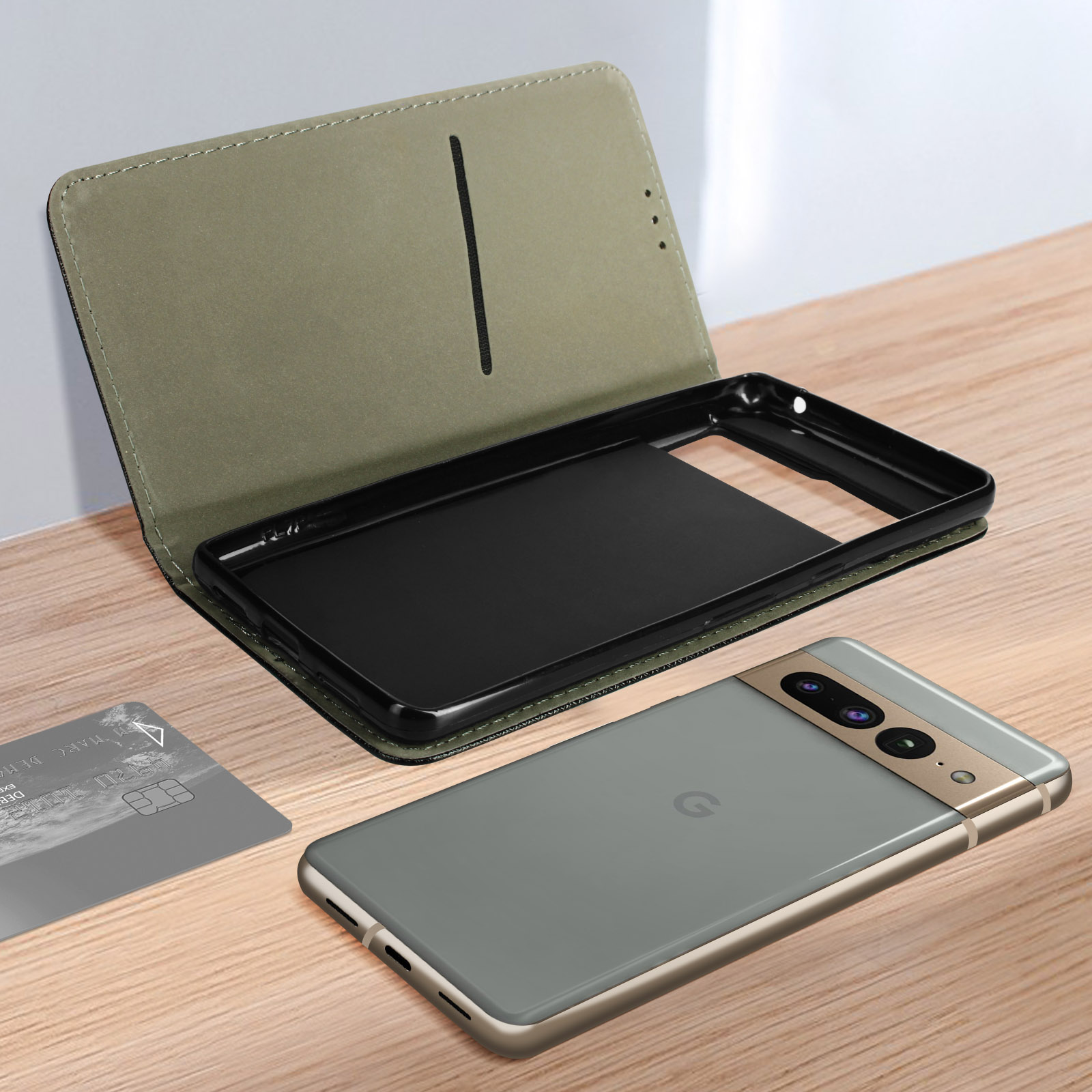 Custodia grigia per telefono con coperchio aperto e telefono, una carta di credito poggia su una superficie di legno.