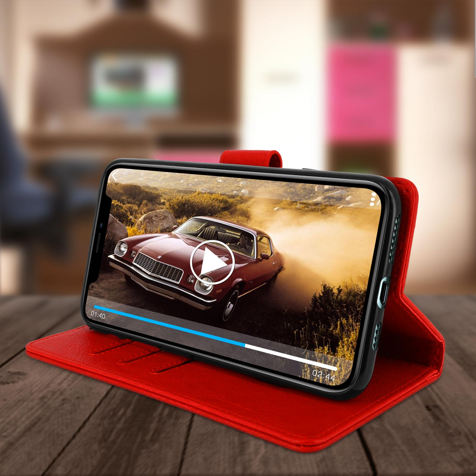 Telefoon in rode hoes met een autovideo. Hoes is open op houten oppervlak, achtergrond wazig.