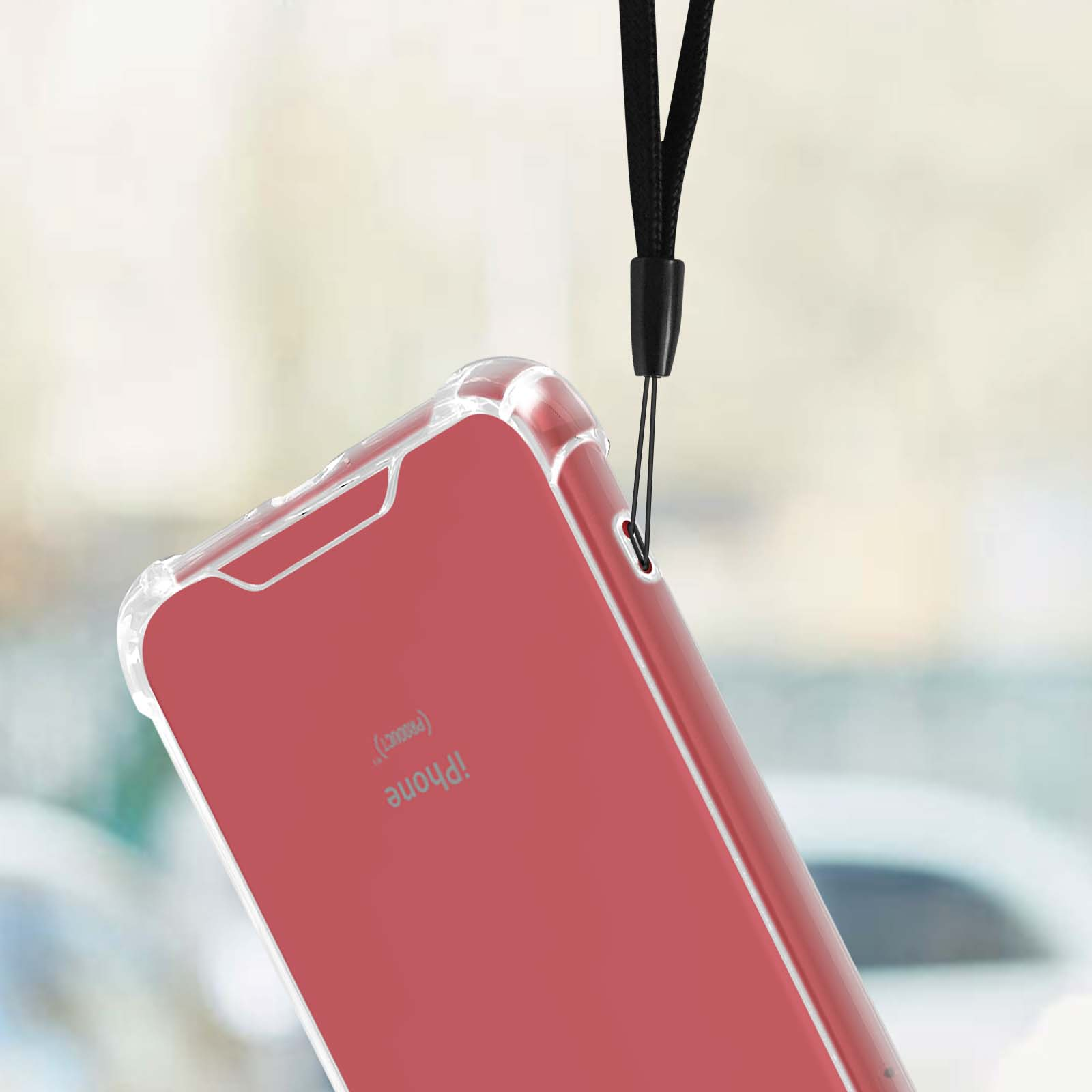 Un telefono in una custodia trasparente con un cordino nero, sfondo sfocato.