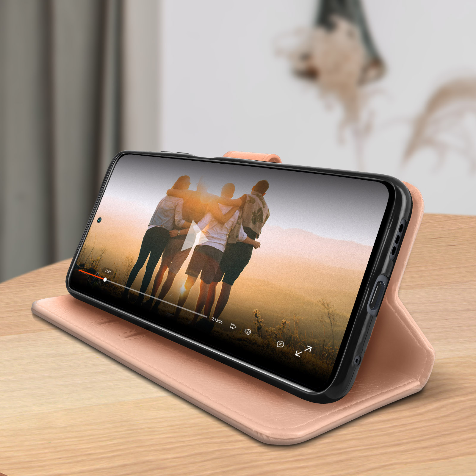 Teléfono en funda, mostrando un video. Sobre una superficie de madera.