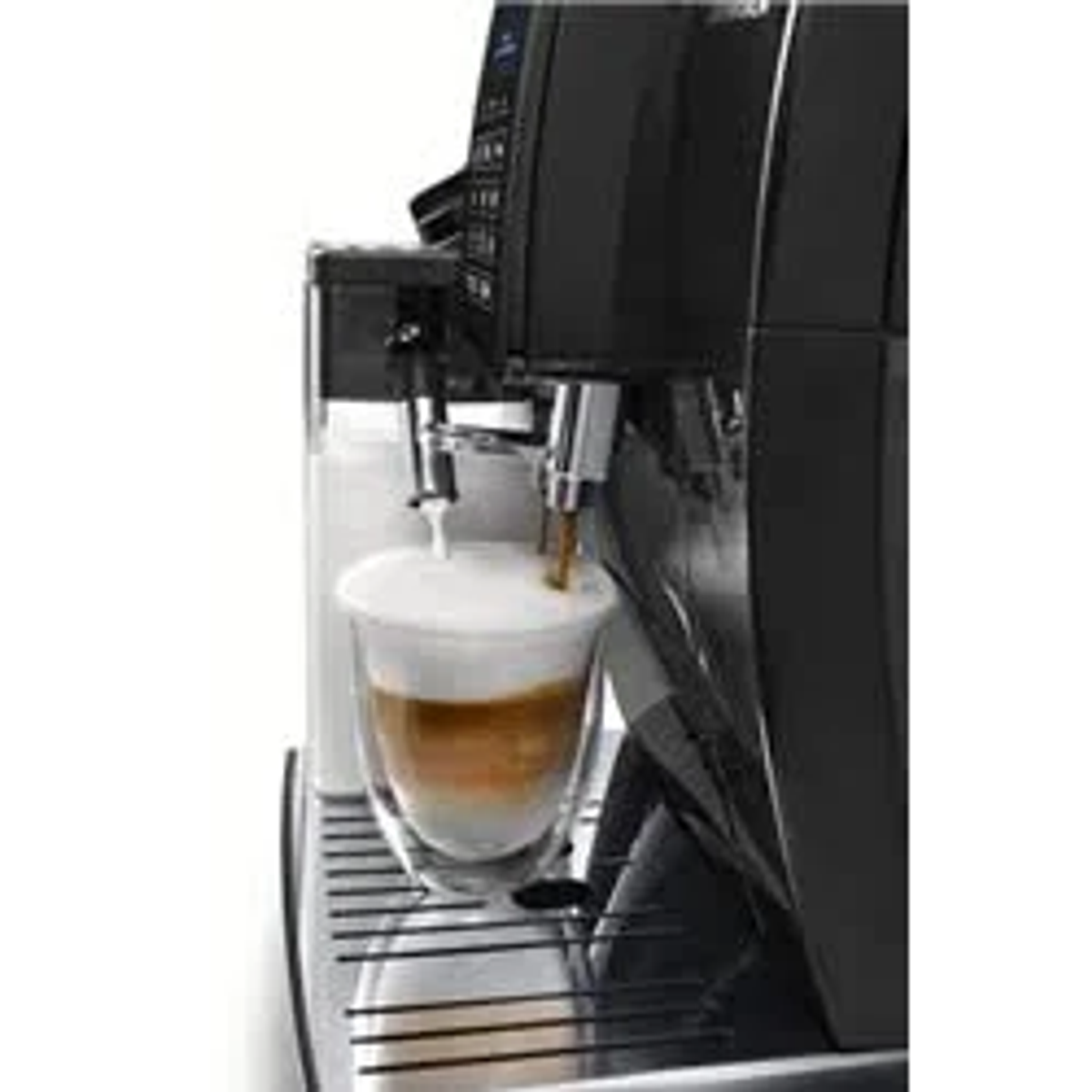 Una macchina per espresso versa il caffè in un bicchiere. Un contenitore di latte è a sinistra.