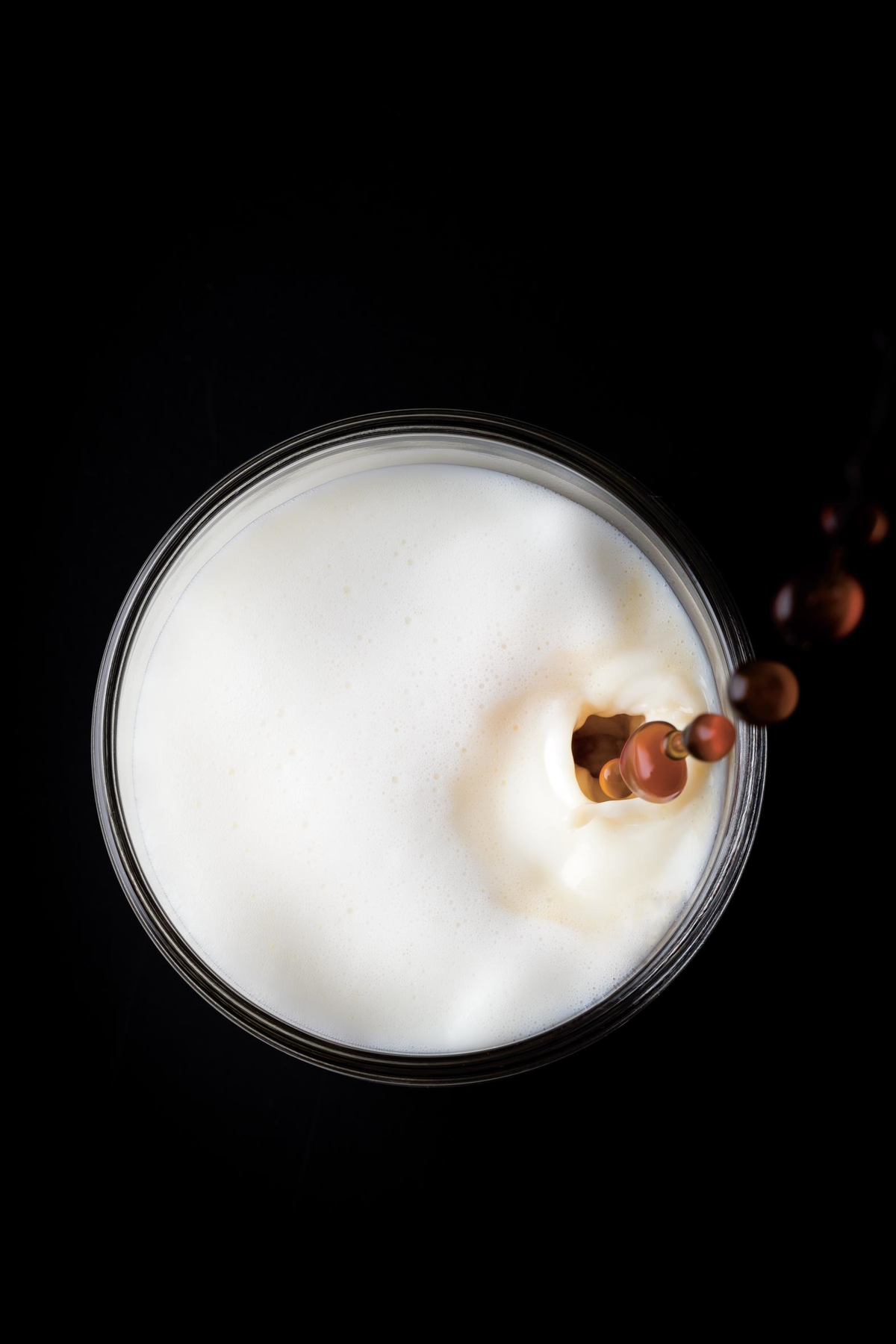 Ujęcie z góry szklanki mleka z kroplami czekolady wpadającymi do środka.