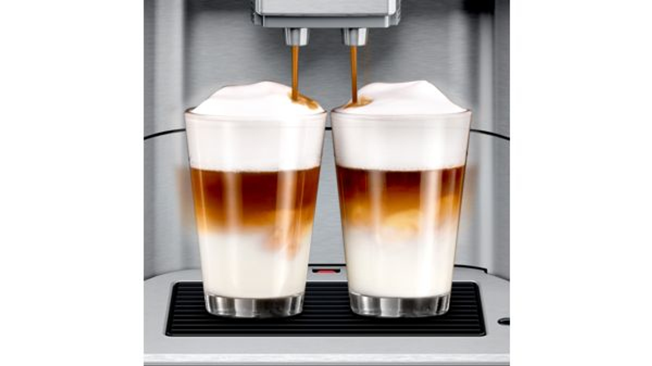Coffee machine pouring latte macchiato into two glasses.