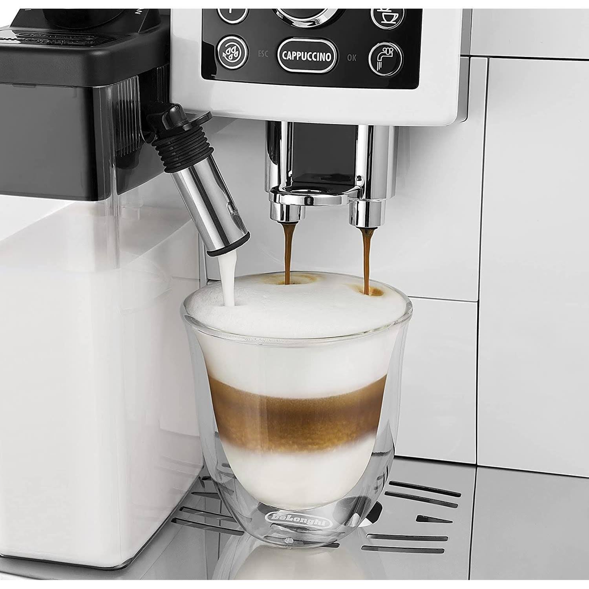 Máquina de espresso dispensando café y leche en un vaso, creando una bebida en capas.