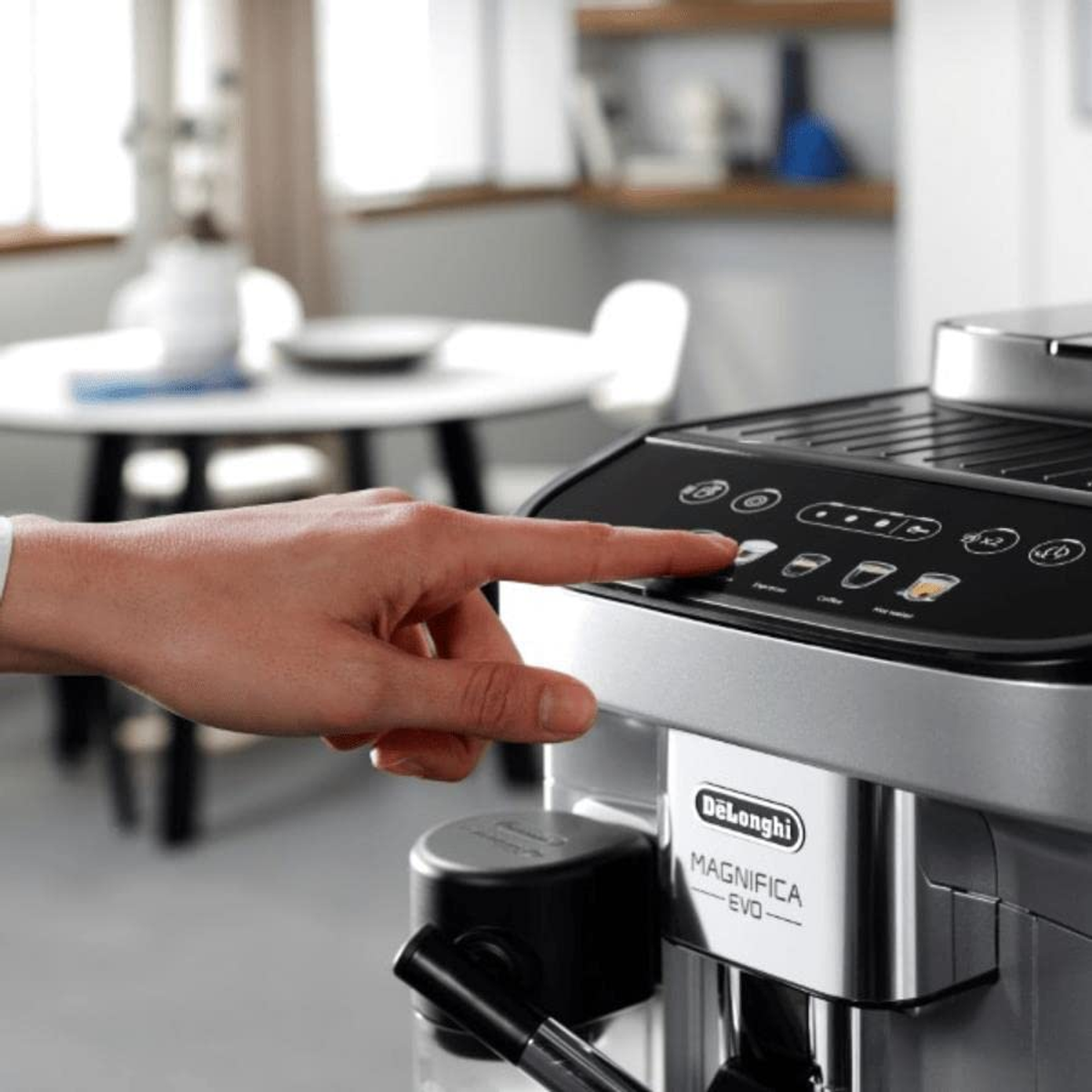 Ręka naciska przycisk na ekspresie do kawy z logo Delonghi.