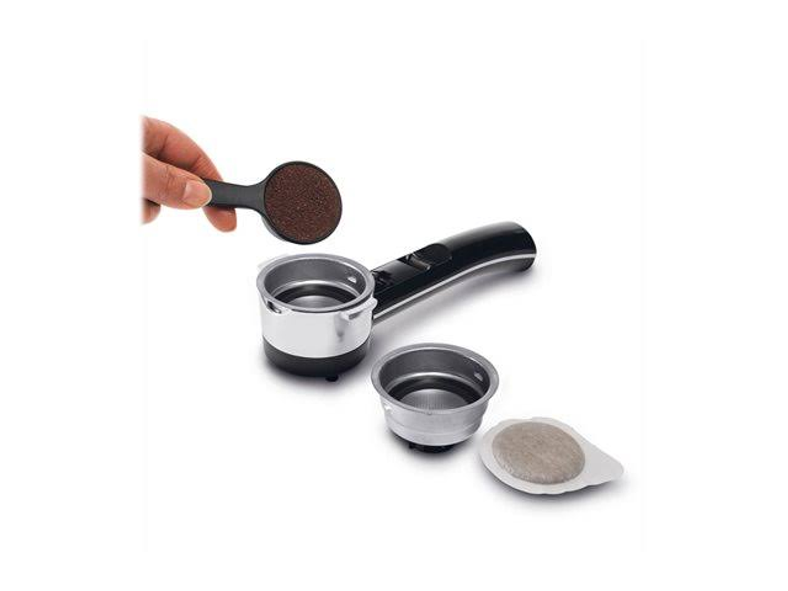 Ręka trzymająca miarkę zmielonej kawy nad kolbą z dwoma koszyczkami filtracyjnymi i saszetką kawy.