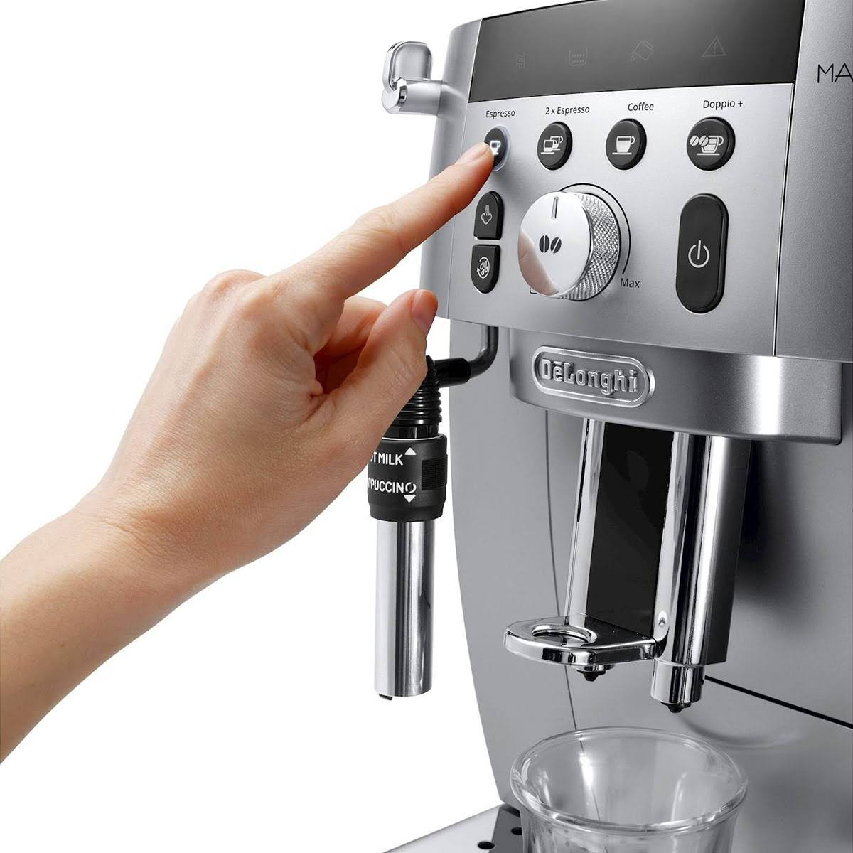 Dłoń naciska przycisk espresso w ekspresie De'Longhi. Srebrny z przyciskami.