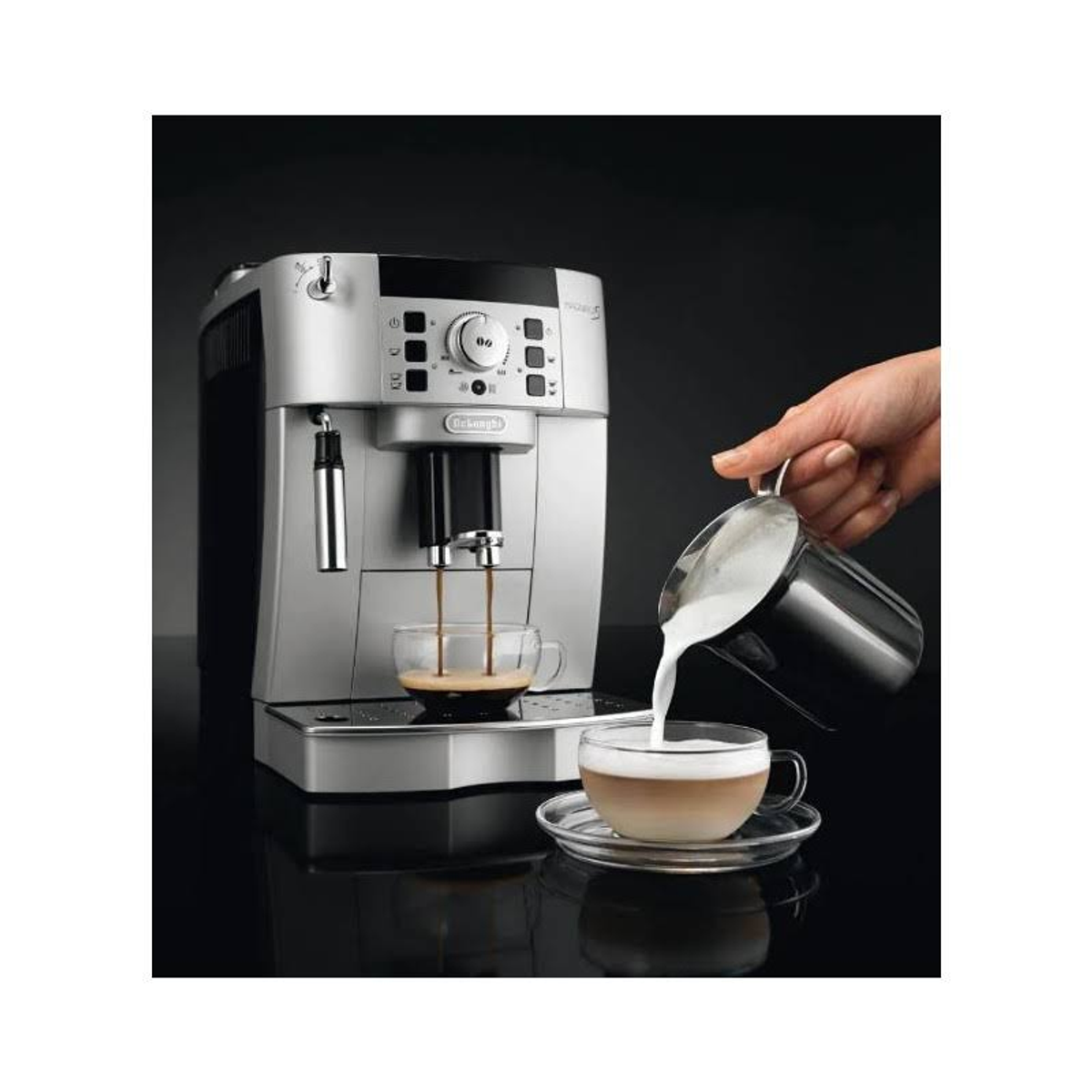 Srebrny ekspres do kawy z kawą wlewaną do szklanek; dłoń wlewa mleko do filiżanki.