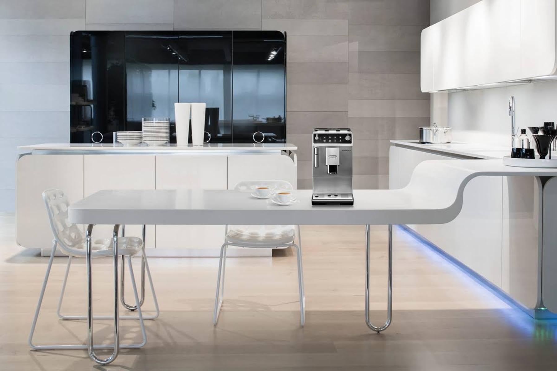 Nowoczesna kuchnia z białymi meblami i ekspresem do kawy na stole. Obecne są krzesła.