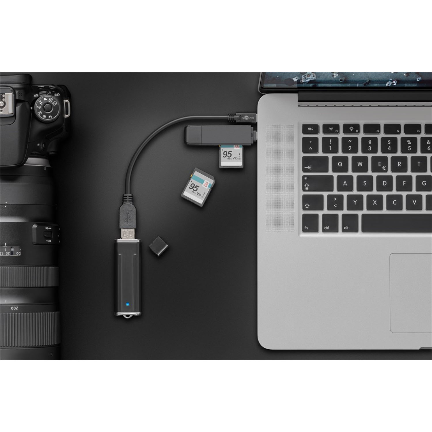 A laptop, camera, and SD card reader connected by USB on a black surface. The SD card is inserted.