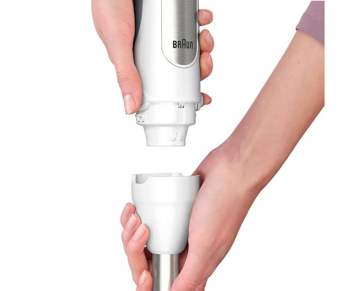 Ręce trzymające biały blender ręczny Braun i mocujące część z ostrzem.
