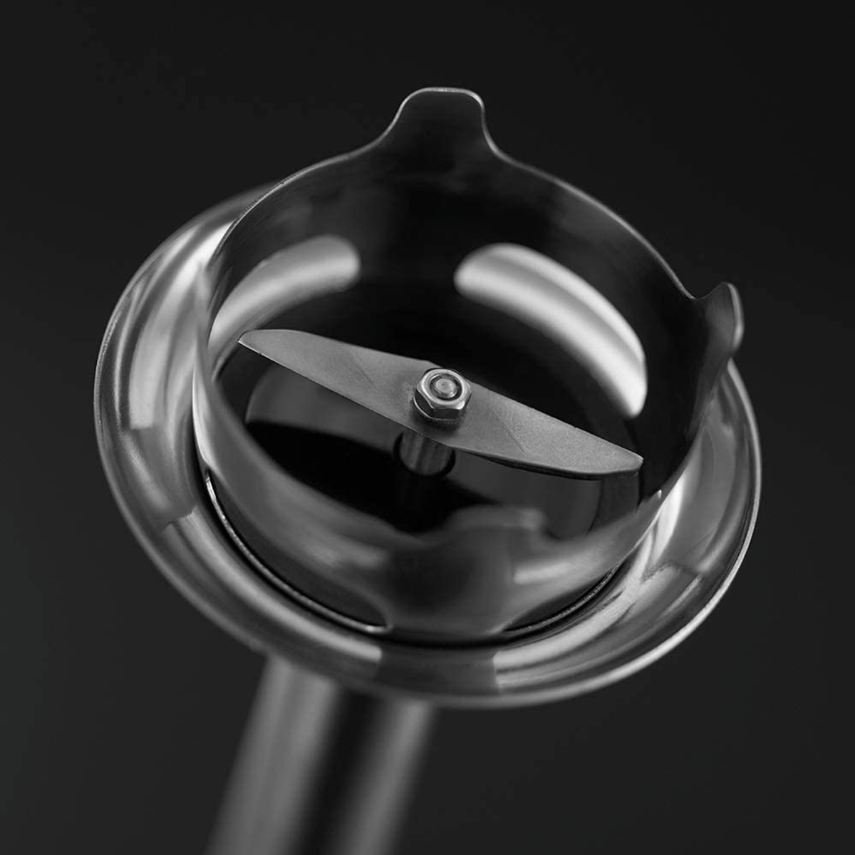 Siyah arka plan üzerinde metal bir muhafaza içinde gümüş bir bıçak bulunan bir blender bıçağı ataşmanının yakın çekimi.