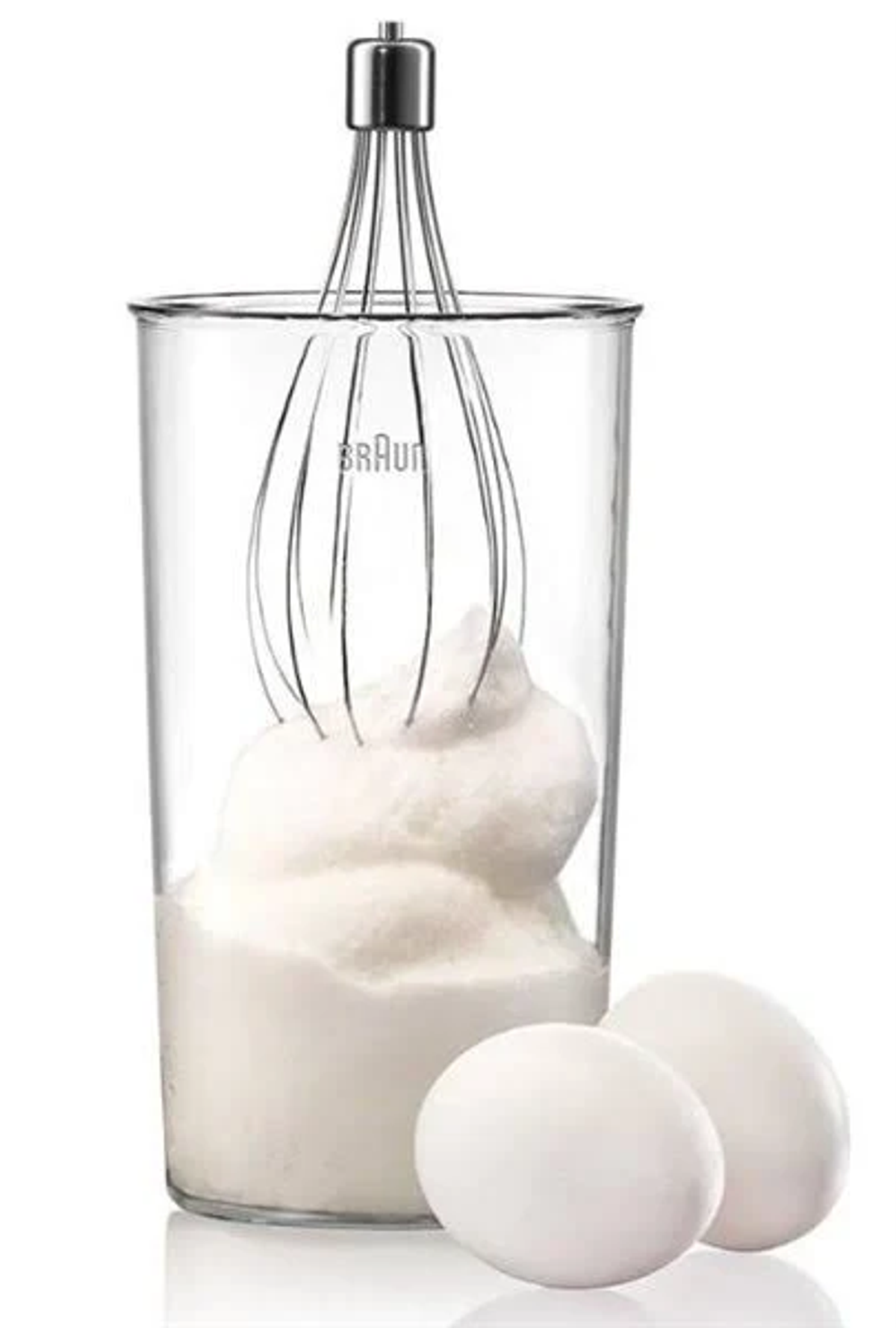 Un becher trasparente con una frusta all'interno, riempito con albumi montati e due uova.