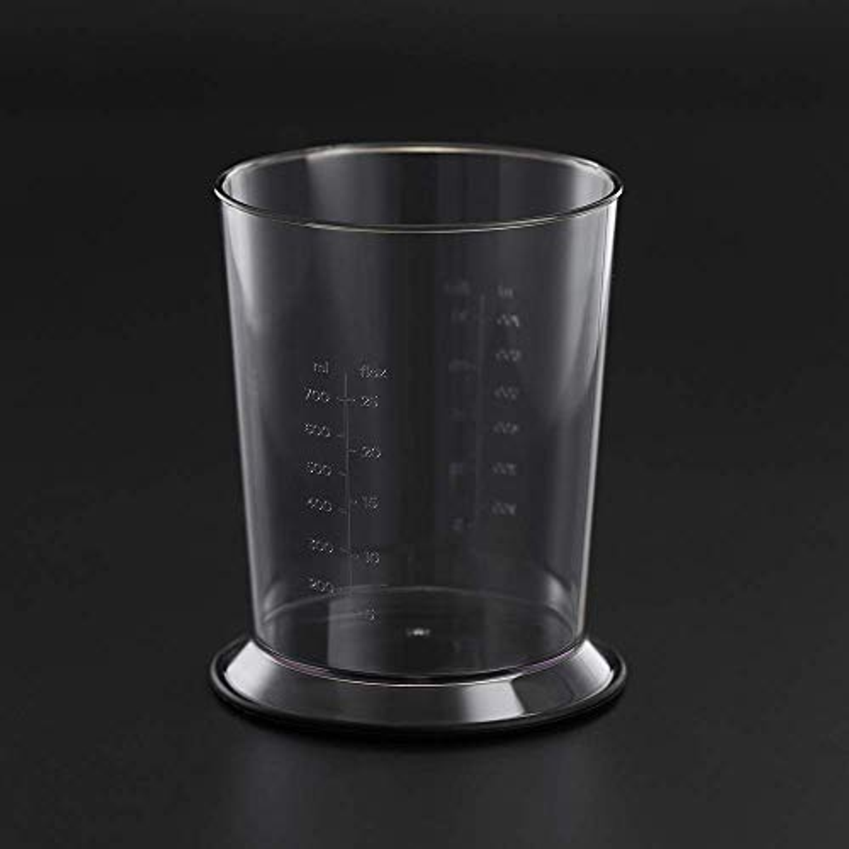 Przezroczysty kubek z miarką na czarnej powierzchni. Kubek jest pusty.