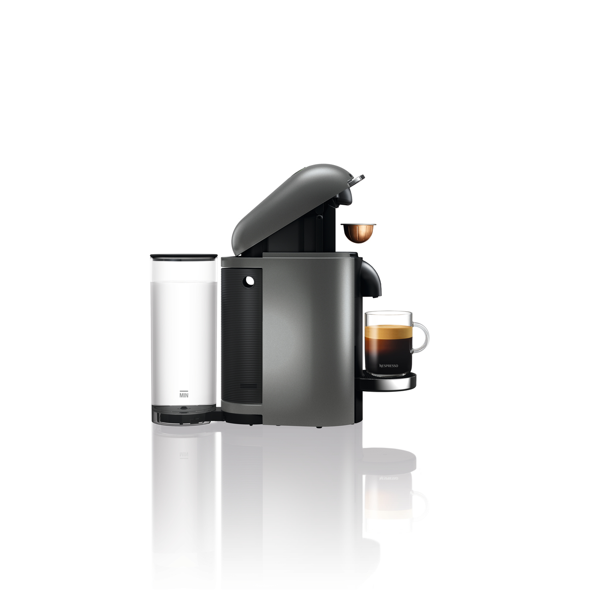 Eine graue Nespresso-Kaffeemaschine mit einer Tasse Kaffee und einem Wasserbehälter, alles auf weißem Hintergrund.