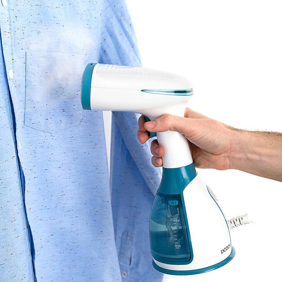Una mano che stira una camicia blu con un vaporizzatore bianco e verde. Sfondo bianco.