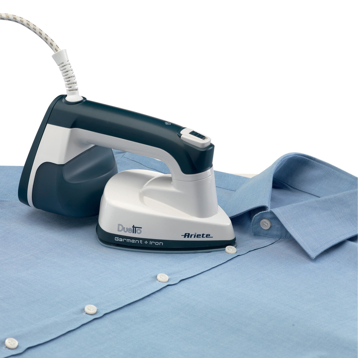 Una camisa azul se plancha con una plancha de ropa pequeña, blanca y verde azulado. Marca Ariete.