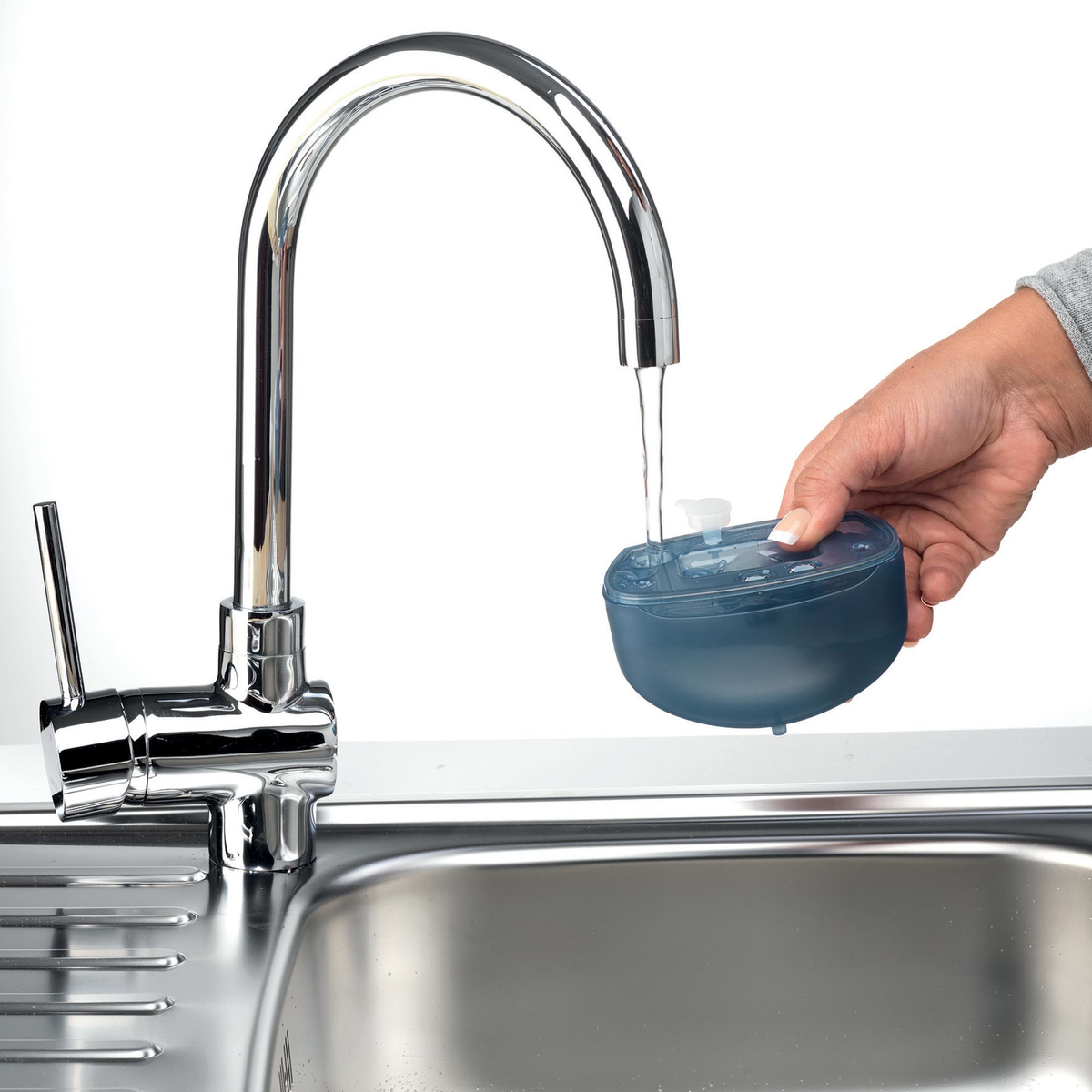 Una mano llenando un recipiente azul con agua de un grifo.
