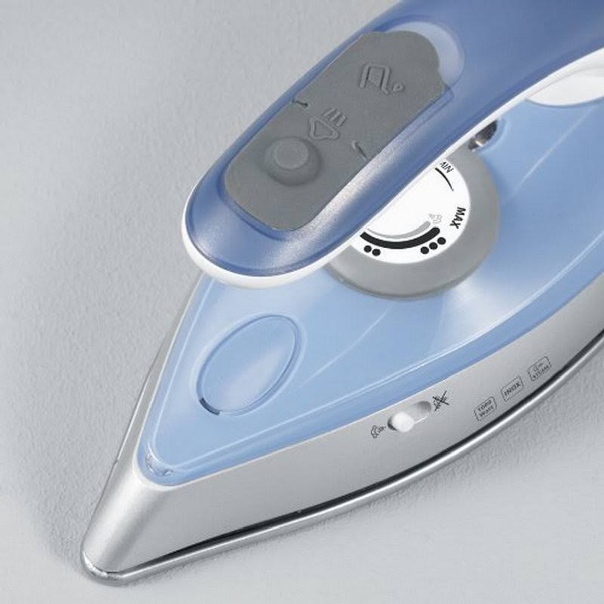 Close-up of a blue and white iron base with settings and a clear plastic cover.
