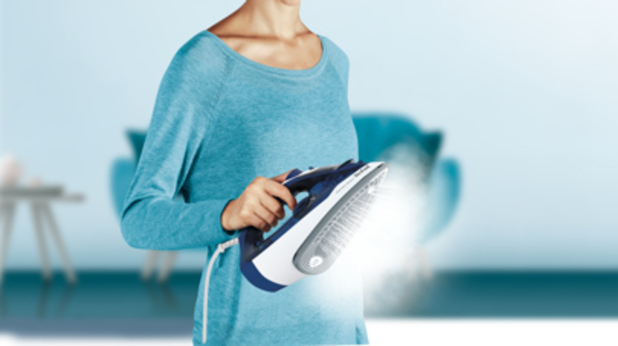 Mujer sosteniendo una plancha. Sale vapor. La plancha es azul y blanca.