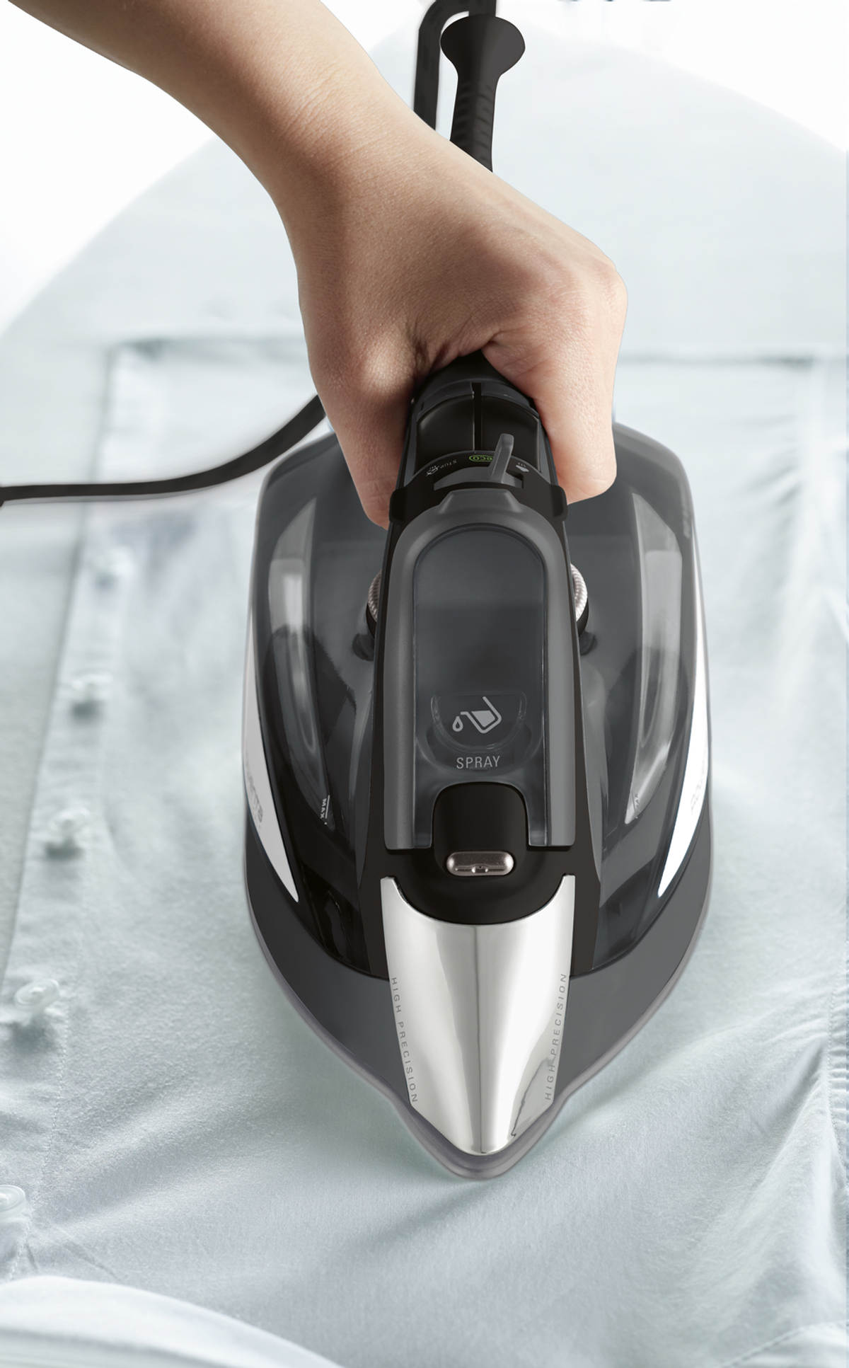 Osoba prasująca błękitną koszulę. Żelazko jest czarne i srebrne. Żelazko jest na koszuli.