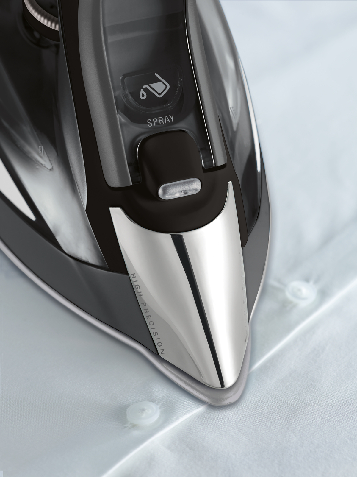 Zbliżenie końcówki czarno-srebrnego żelazka, z przyciskiem spryskiwania.